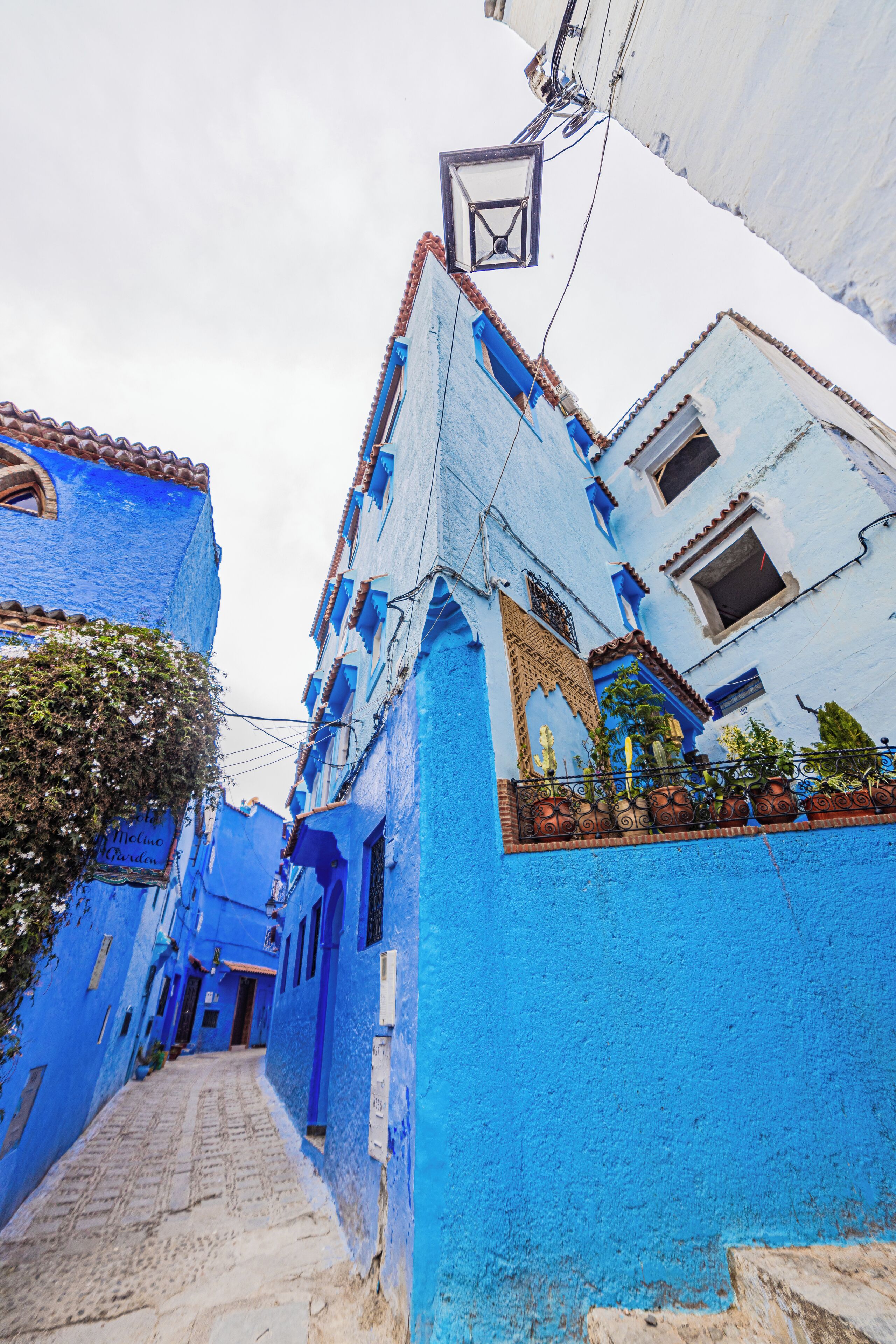 A narrow street with buildings painted in a bright blue color.