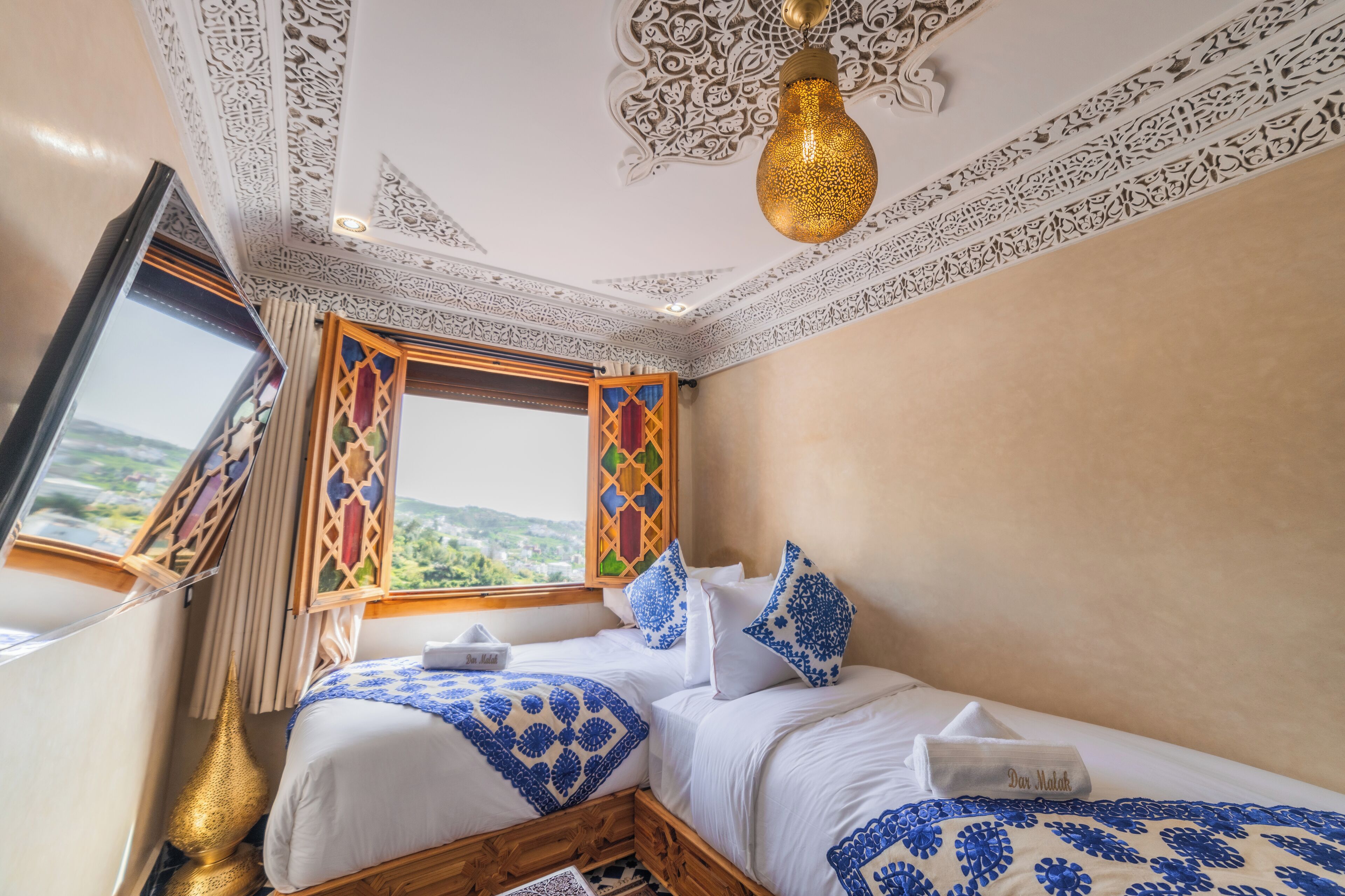 Ein Hotelzimmer mit Bett, Fenster mit Blick und aufwendigen Deckenmustern.