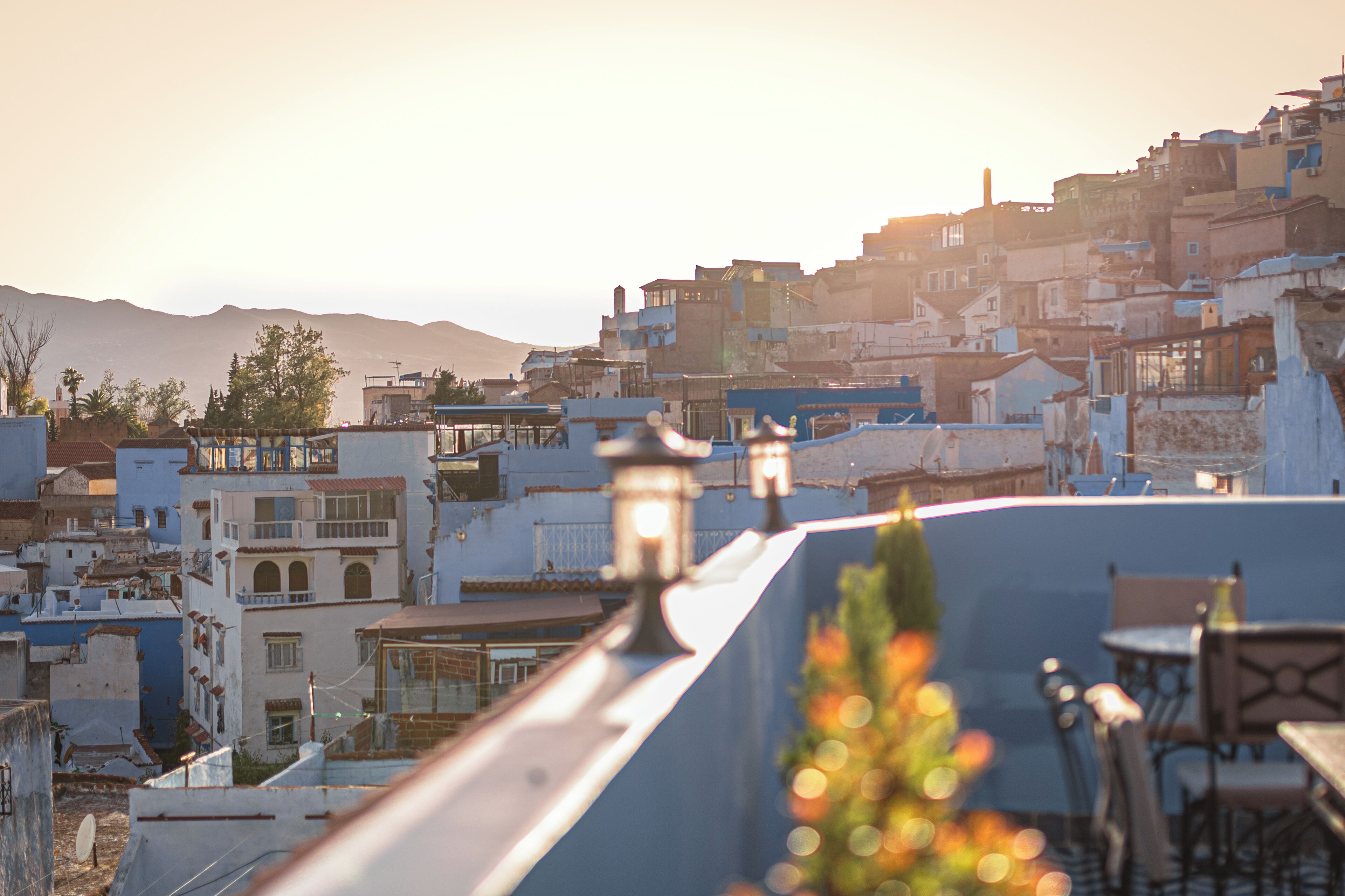 Eine Dachterrasse mit Blick auf eine dicht bebautes Stadtgebiet, einschließlich Gebäude und ein Berg im Hintergrund.