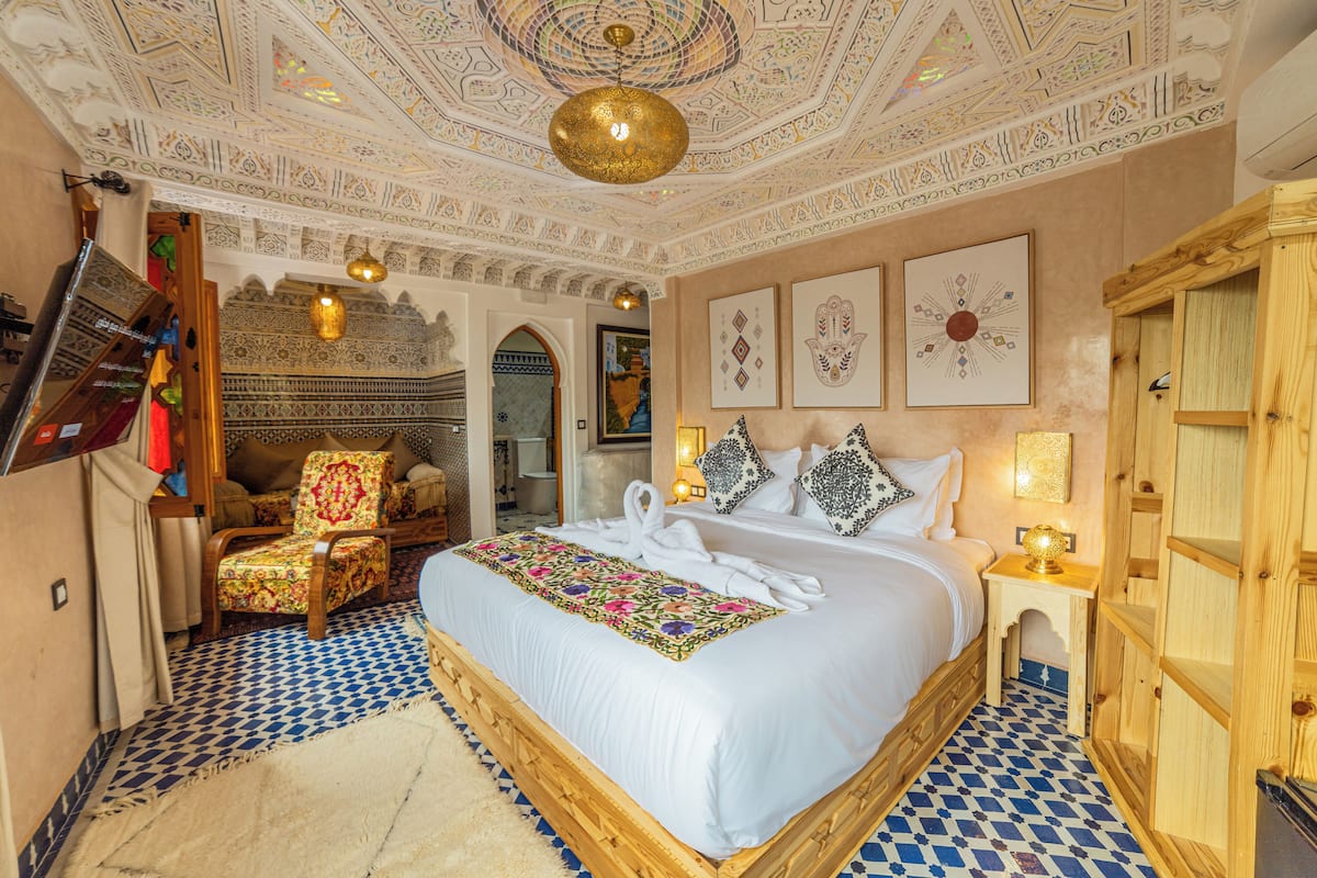 A room with a large bed, a wooden cabinet, and a patterned floor.