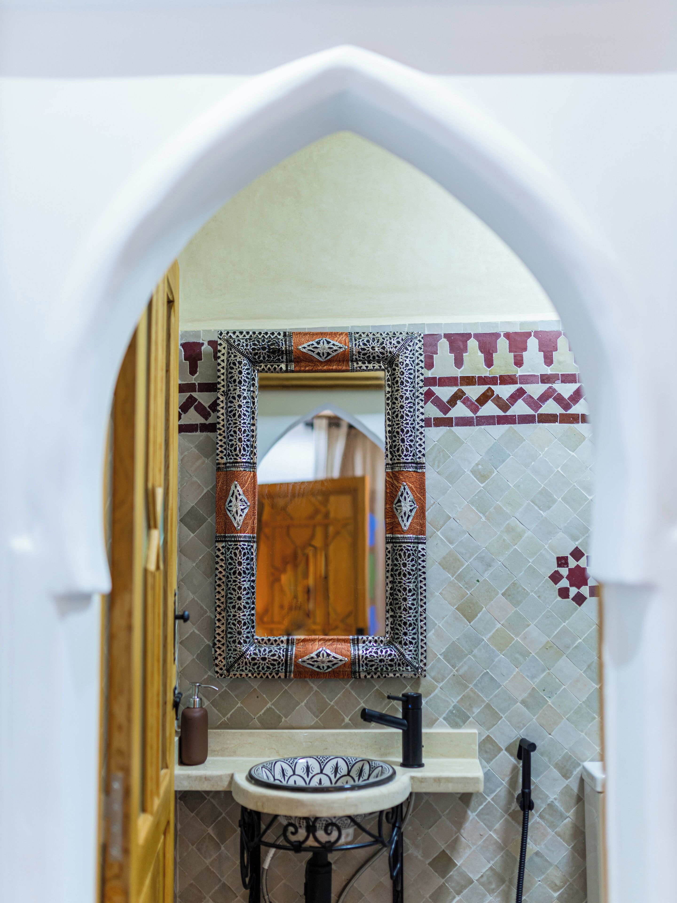 A bathroom with a sink, mirror, and shower.