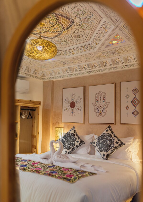 Une chambre d’hôtel avec un lit, des oreillers et des œuvres d’art murales.