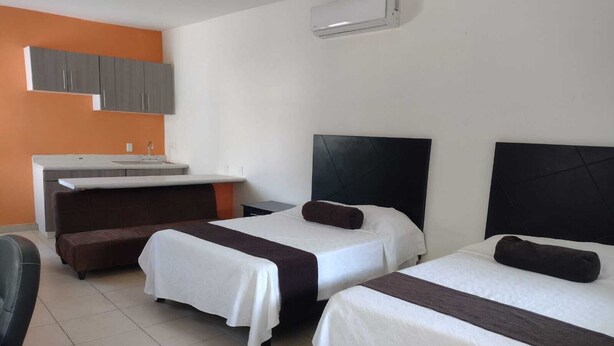 A hotel room with two beds, a sofa, a small desk, and a kitchenette. - Hotel Centro Valles  (Ciudad Valles)
