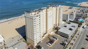 Un hôtel de grande hauteur, avec de nombreux étages, un parking et une vue sur la plage.