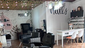 A salon with multiple black salon chairs, a white desk, and a wall with 'PEDICURE' and 'Nails' written on it. - NEIZAN HOTEL (Antigua Guatemala)
