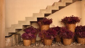 Een trap met rieten manden vol paarse bloemen.