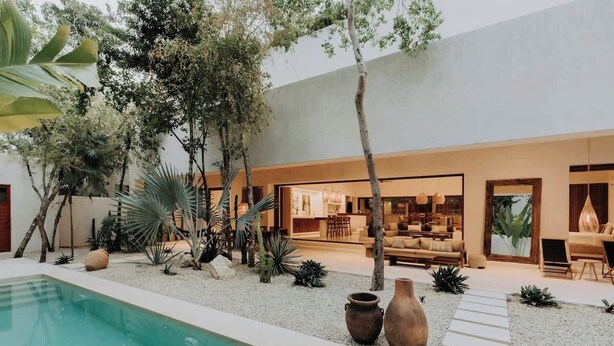 Un espacio exterior moderno con piscina, asientos y zona de comedor.