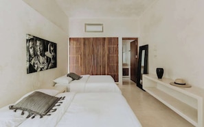 A room with two beds, a wooden slat wall, a white shelf, and a framed picture on the wall. - Casa Fuego Sanctuary Villa Private Chef Beach Club (Tulum)