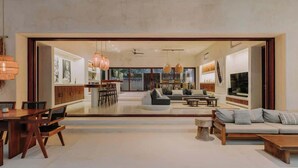 Un salón espacioso con una mesa de comedor, sofás y un televisor.