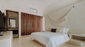 Un dormitorio moderno con cama, mesitas de noche, una silla colgante y un panel de pared de madera.