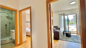 A modern apartment with a shower, a bed, a balcony, and a dining area. - Central apartments Surina (Budva)