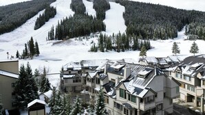 Un centro de esquí con pistas cubiertas de nieve y edificios tipo refugio.