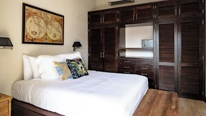 A bedroom with a large bed, dark wooden wardrobe, and a world map on the wall. - Una Villa Colonial con Encanto en el Corazón del Casco Antiguo (Panama)