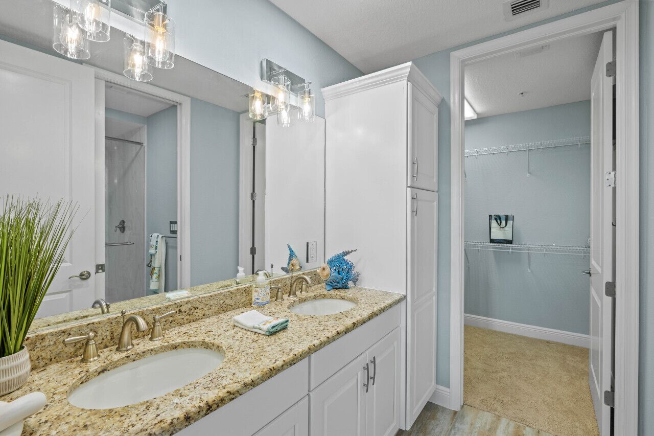 A bathroom with two sinks, a large mirror, and a shower area.