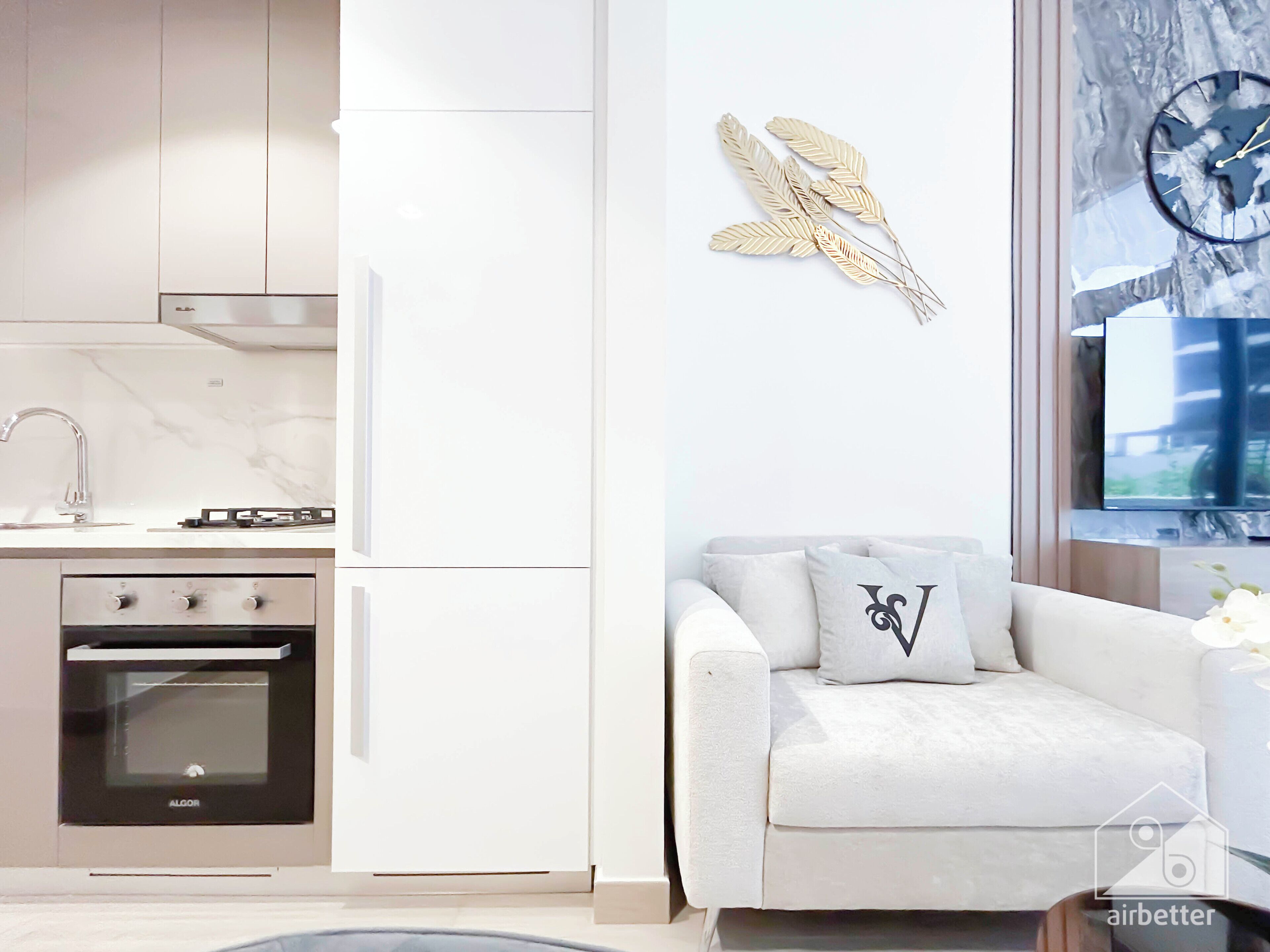 Une cuisine moderne avec des meubles blancs, un four encastré et une cuisinière à gaz.