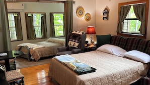 A cozy room with a large bed, a chair, a table, and a fireplace. - Godin's Get A Way,  Creekside cabin, Relax in Murphy, NC.  Close to everywhere! (Murphy)