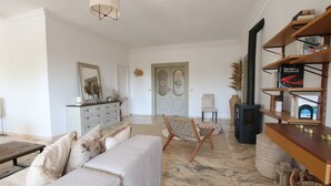 A spacious living room with a sofa, a wooden chair, a bookshelf, and a fireplace. - Tess Villa Olmos in M Laga (Málaga)