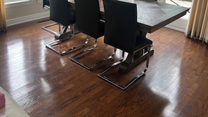 Een eetgedeelte met een houten tafel, zwarte stoelen en een kroonluchter.