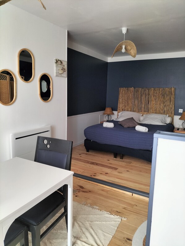Un dormitorio moderno con una cama, mesitas de noche, un escritorio y una silla.