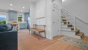 Une cuisine moderne avec des meubles de couleur bleu clair, un banc en bois et un escalier doté d’étagères intégrées.
