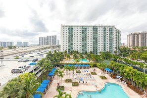 Ein Hotel mit Swimmingpool, mehreren Etagen und einem Parkplatz.