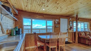 L’intérieur d’un chalet en bois comprend une cuisine, un coin repas et un canapé.