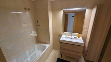 Een haardroger, handdoeken, zeep, toiletpapier