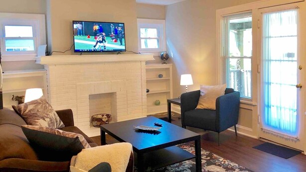 A living room with a fireplace, a television, and a sofa. - Spacious 1BR - Great Location @ Grandview & OSU! (Columbus)