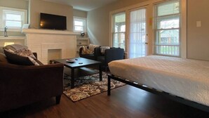 A modern living room with a sofa, a coffee table, a TV, and a fireplace. - Spacious 1BR - Great Location @ Grandview & OSU! (Columbus)