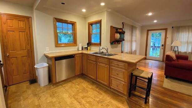 A kitchen with wooden cabinets, a sink, and a window. - Clintonville Charmer | Walk to Great Restaurants! (Columbus)