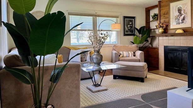 A living room with a sofa, armchair, coffee table, and a fireplace. - Westerville Comfort & Convenience (Westerville)
