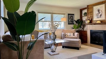 A living room with a sofa, armchair, coffee table, and a fireplace.