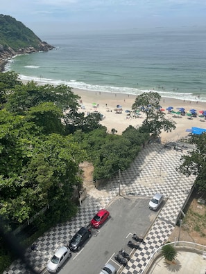 A beach with a parking area and a view of the ocean. - Apartamento Completo NO Guarujá - Praia DO Tombo - PÉ NA Areia (Vila Alzira Guarujá)