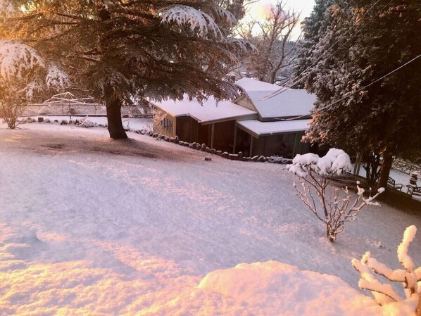 A house with a snow-covered roof and yard.