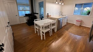 Una cocina con una mesa y sillas blancas, una estufa y un fregadero.