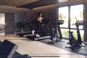 A modern gym with treadmills, an elliptical, and a stationary bike. - Superb citycentre new built flat and gym (York)