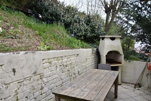 Enjoy outdoor dining and cooking in this patio area with an oven and water source.