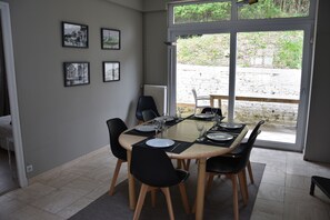 Enjoy meals in this dining area with a table for four, surrounded by framed artwork and a view of the outdoor space.