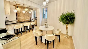 A modern kitchen with a stone backsplash, a round dining table with six chairs, and pendant lighting. - House in the shadow of the Colosseum (Roma)