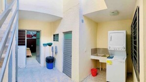 A narrow outdoor corridor with a laundry area, a door leading to a room, and a trash bin. - Casa San Rafael Guadalajara CENTRICO (Guadalajara)