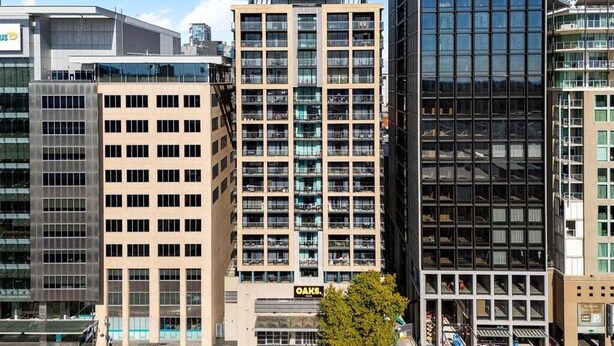 A multi-story building with a modern architectural design, featuring a prominent central entrance and a glass facade. - 1BR Apartment on North Terrace (Adelaide)