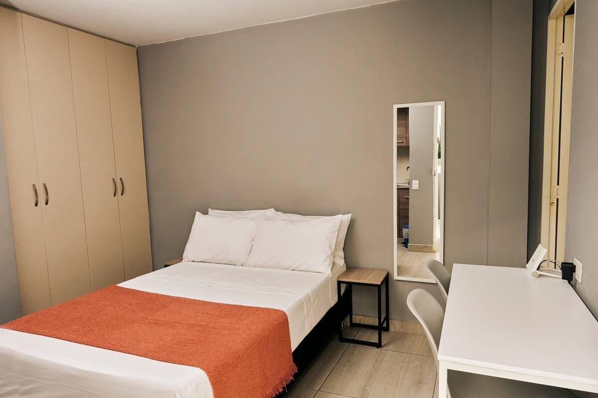 Ein Schlafzimmer mit einem Bett, einem Schreibtisch und einem Kleiderschrank.
