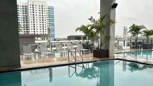 A rooftop pool with clear views of a cityscape, including a tall building. - Sleek Urban Living Stylish 1BR in Brickell (Miami)