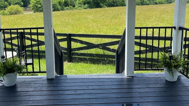 A covered porch with a view of a green field and trees. - Riverfront Tiny Home - Amazing Views (Strawberry Plains)