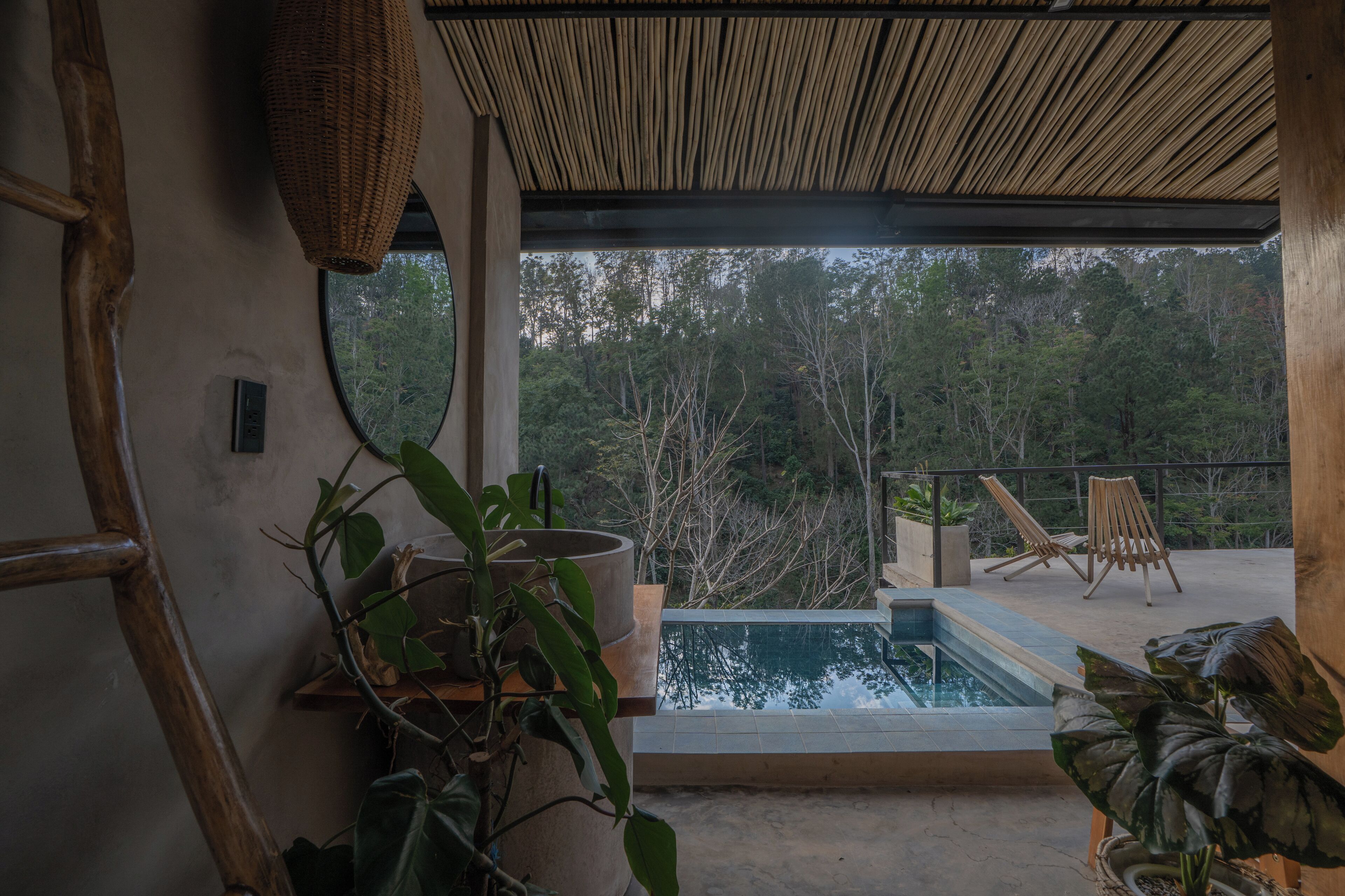Ein modernes Interieur mit einem großen Fenster, das einen Pool und üppiges Grün zeigt.
