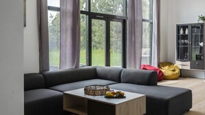 Ein modernes Wohnzimmer mit einer Eckcouch, einem Holztisch und einer Glasschrank mit Dekoration.