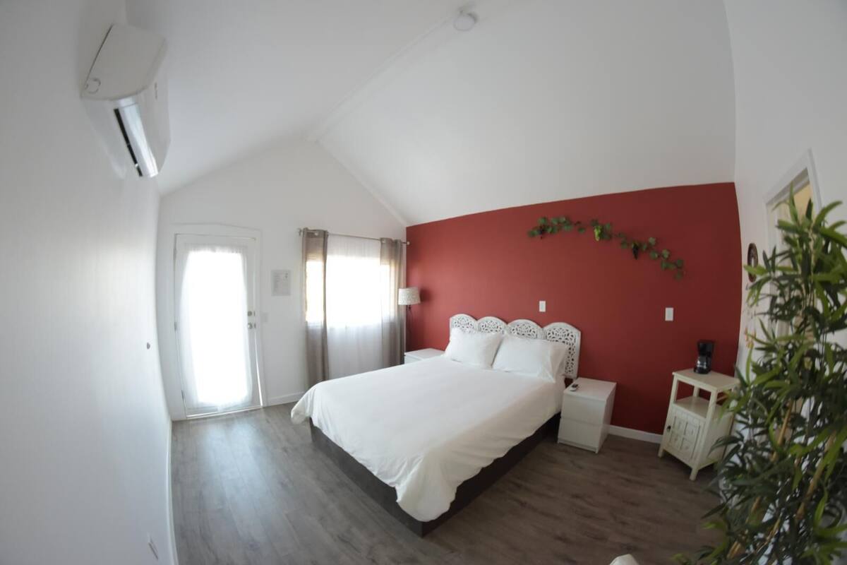 Una camera da letto con un letto, un comodino e una pianta.