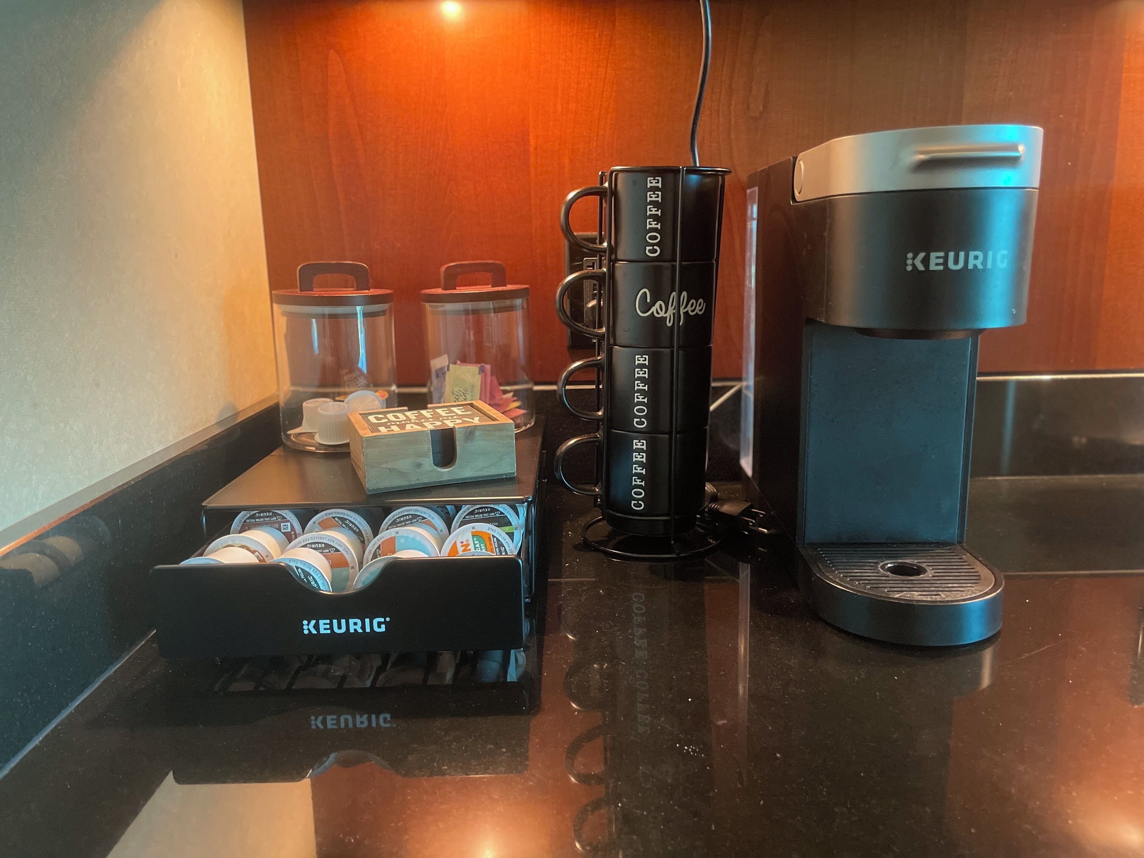 A coffee station with a Keurig coffee maker, coffee pods, and a coffee mug.