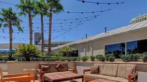 An outdoor seating area with wooden furniture and a view of a building with a modern design. - Renovated Luxury Studio Suite in Tower 3, New Luxury Suite Tower 3 (Paradise)
