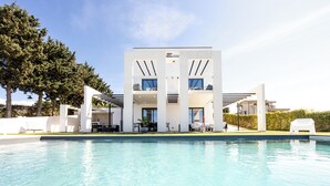 A modern building with a pool, outdoor seating, and a clear sky. - Modern Villa for Groups with Pool, Spa & Sea View | 13 Guests | Sicily (Partinico)